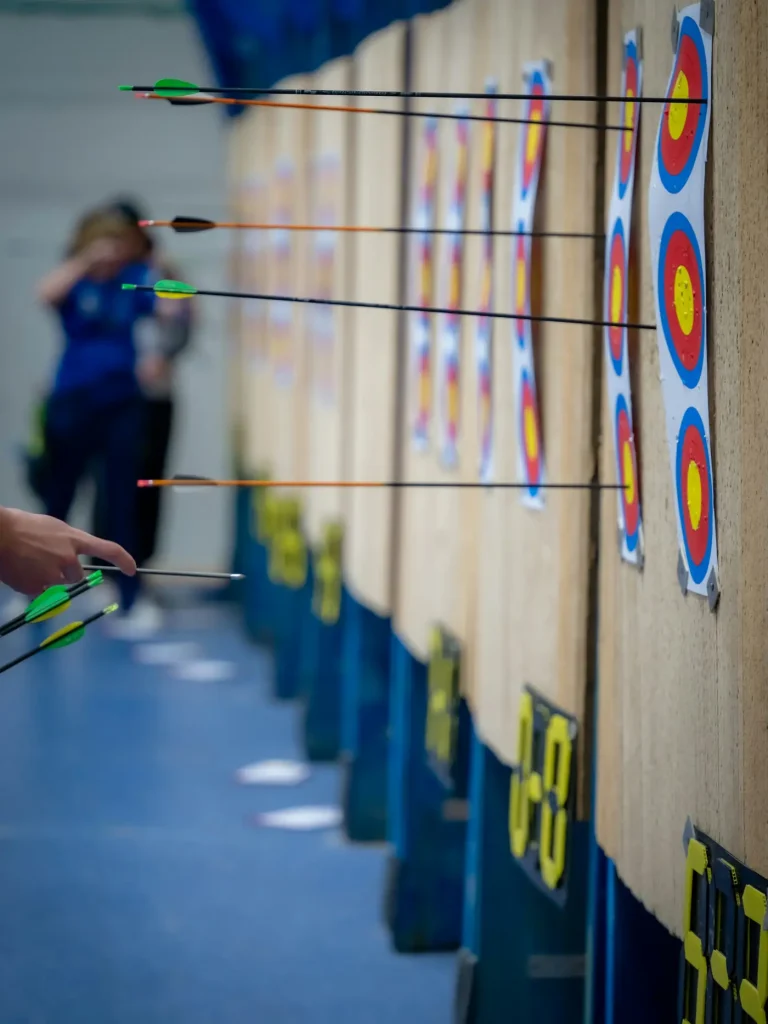 Zielscheiben in einer Sporthalle, Pfeile stecken in den Auflagen